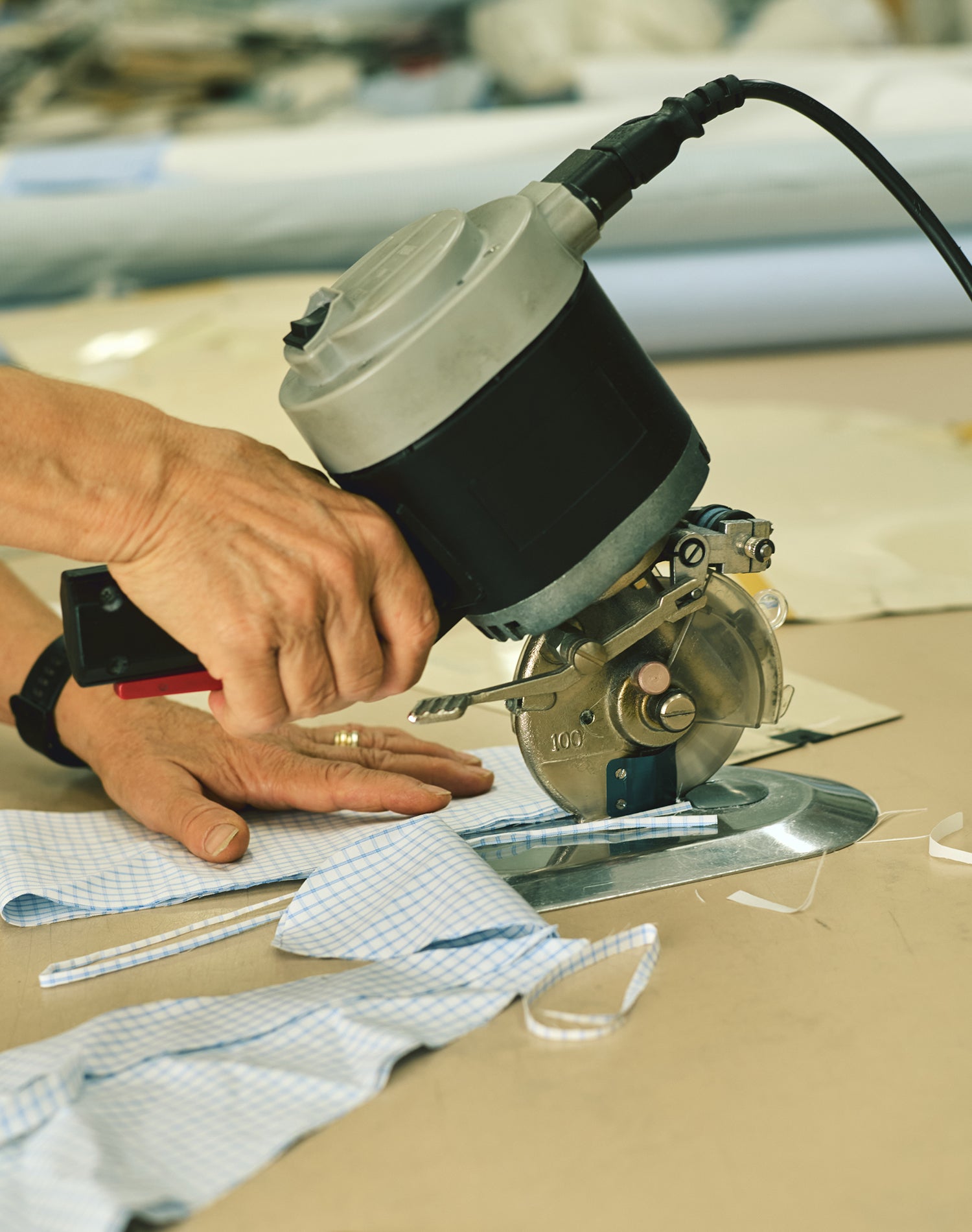 Taglio del tessuto a mano nel laboratorio sartoriale Agenorie